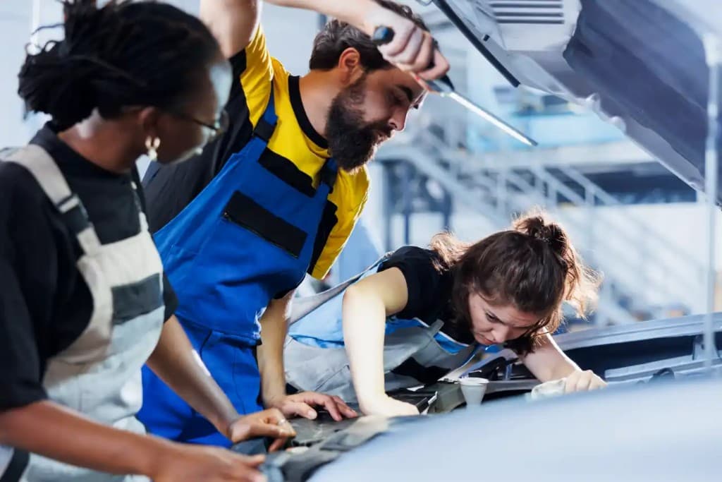 Technicians working together on a vehicle engine bay