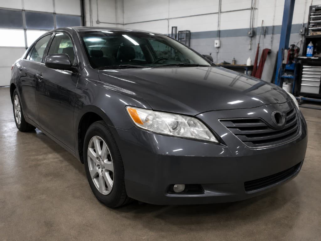 Dark grey sedan with a high-gloss factory-quality finish after paintwork